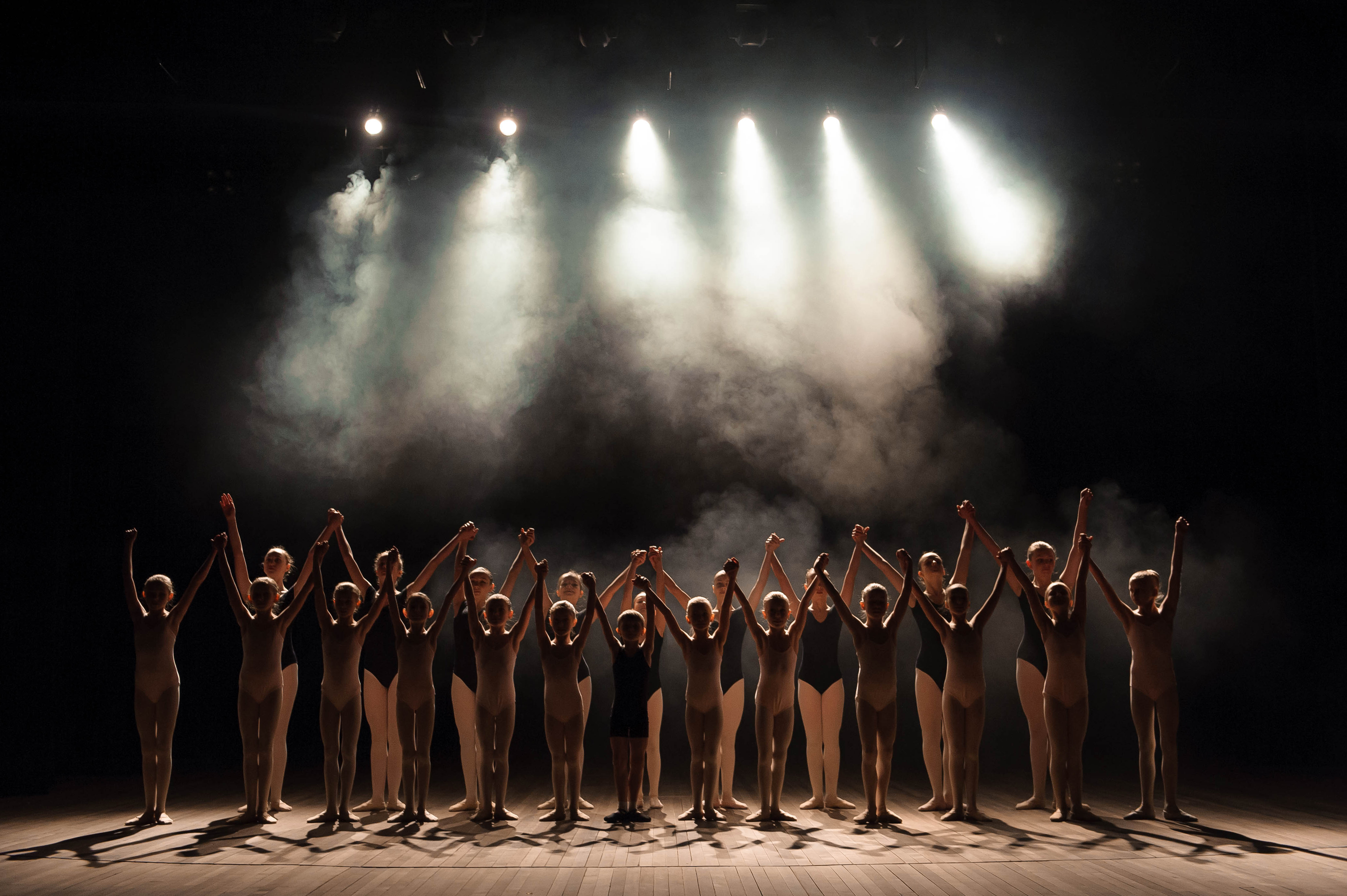 a large group of children have a reverence at the end of the performance.
